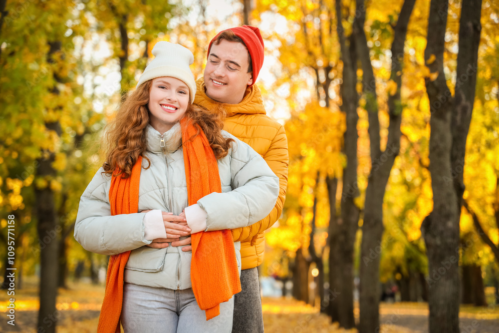 Beautiful loving young happy couple hugging in autumn park