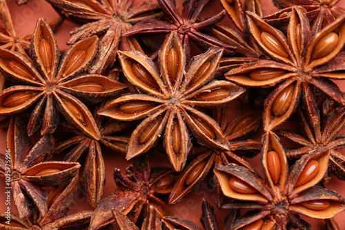 Fototapeta Naklejka Na Ścianę i Meble -  Heap of aromatic star anise on color background, closeup