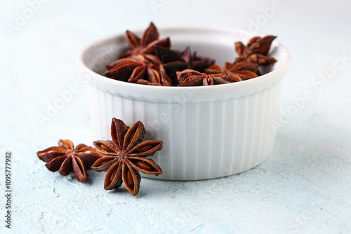 Fototapeta Naklejka Na Ścianę i Meble -  Bowl with aromatic star anise spice on light background