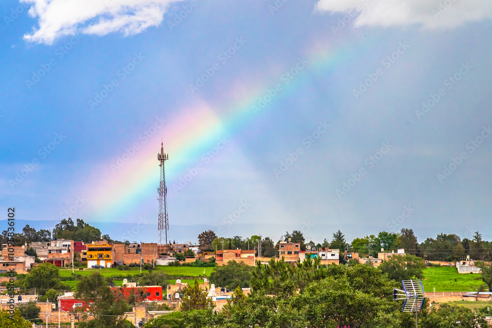 Fototapeta premium Rainbow over a town on a rainy day, in Monte Escobedo, Zacatecas