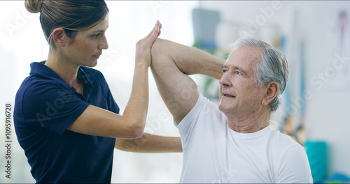 Physiotherapy, woman and elderly man with shoulder pain for stretching, help or care in office. Chiropractor, senior patient or support in practice for rehabilitation, healing or arm exercise in exam