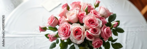 A vase filled with freshly picked Blossoming Grace roses is placed on a white tablecloth showcasing the beauty of the roses in a simple setting, tablecloth, vase
