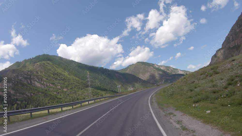 Driving in a car along the mountain road of the Chuya Highway or the Chuysky Trakt in Altai. Siberia, Russia Driving in a car along the mountain road of the Chuya Highway or the Chuysky Trakt in Altai. Siberia, Russia