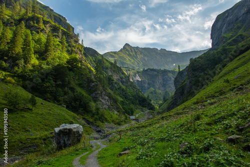 Hiking trail in high mountains, scenery of Alpine valley in summer