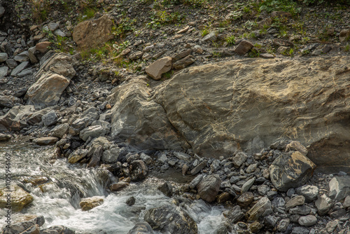 Mountain stream pure water flows on cool rocks close-up, pristine nature background