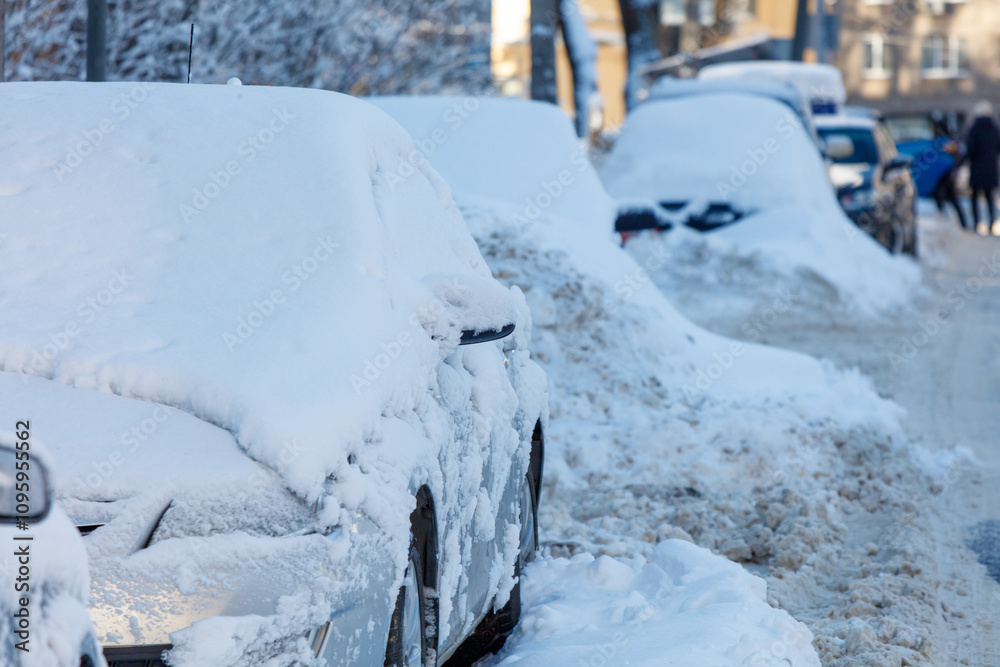 Φωτογραφία A snow covered street with cars parked on it