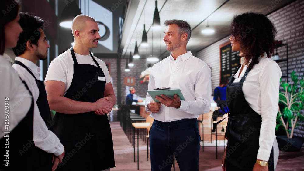Store Manager In Coffee Shop Meeting With Team Store Manager In Coffee Shop Meeting With Team