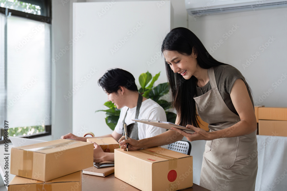 Couple Managing Online Business Inventory and Checking Product Stock in Modern Home Office Setting Couple Managing Online Business Inventory and Checking Product Stock in Modern Home Office Setting