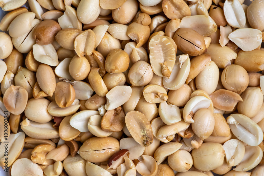 Roasted peanuts (Arachis hypogaea) as background. Peanuts are a popular snack food enjoyed around the world. They can be roasted, salted, or flavored with various spices. Roasted peanuts (Arachis hypogaea) as background. Peanuts are a popular snack food enjoyed around the world. They can be roasted, salted, or flavored with various spices.