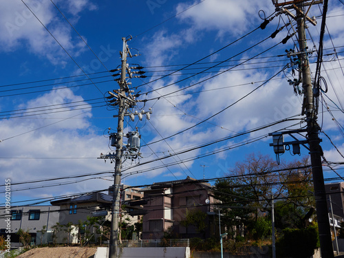 青空と住宅地の電柱と各種のケーブルの風景 photo