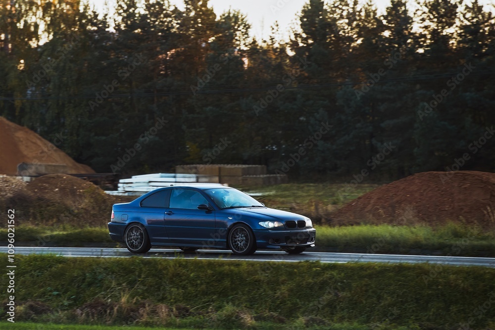Speeding on a Nature Landscape with a Sporty Vehicle in the Evening Light Speeding on a Nature Landscape with a Sporty Vehicle in the Evening Light