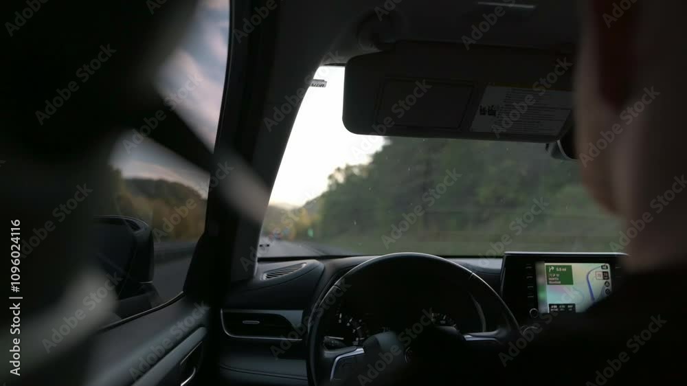 scenic highway drive captured from passengers seat, showcasing driver, GPS navigation system, and road ahead on calm evening. highway drive captured from passengers seat highway drive 