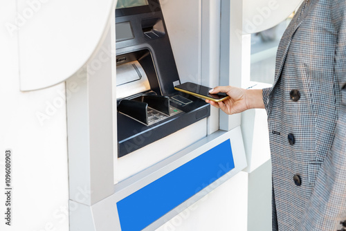 Obraz na płótnie Person using smartphone for cash withdrawal at ATM.