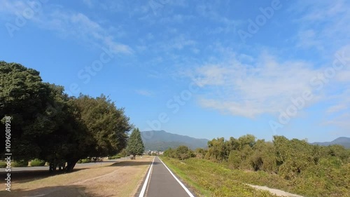 Wallpaper Mural FPV view from an action camera of cycling along Katsura River near Arashiyama under a blue sky on the Kyoto-Nara-Wakayama Cycling Road. A scenic ride through Japanese nature. Torontodigital.ca