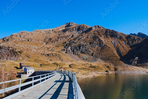 Walkway above the hydroelectric dam at lake Laghi Gemelli. In the background the Pizzo Farno and Monte Corte mountains. Orobie Alps, Lombardy, Italy photo