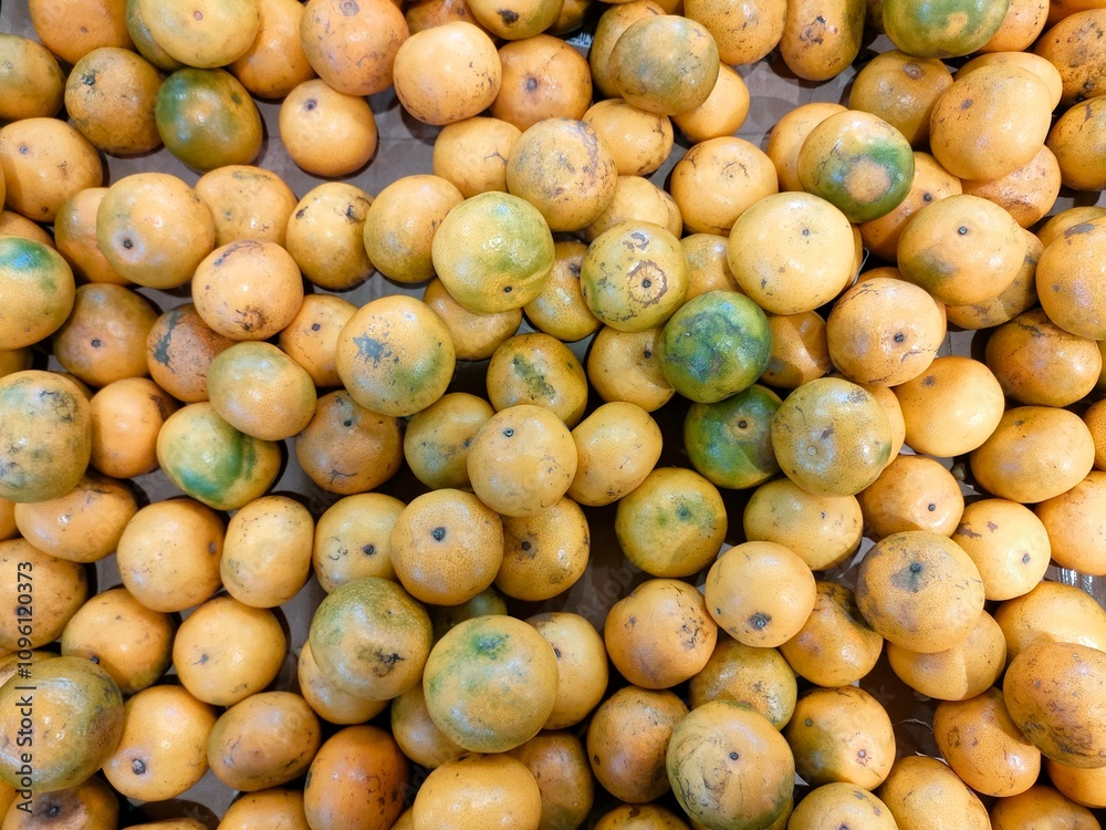 A pile of oranges with yellow skin displayed in a supermarket A pile of oranges with yellow skin displayed in a supermarket