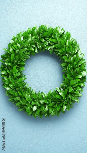 Lush green leaf wreath on a light blue background.