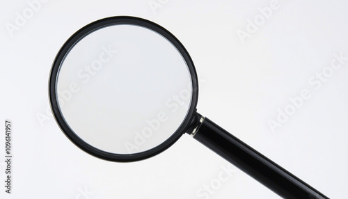The image displays a magnifying glass with a round, clear lens and a black handle. It is positioned against a neutral background. There are no texts or additional objects visible in the image.

