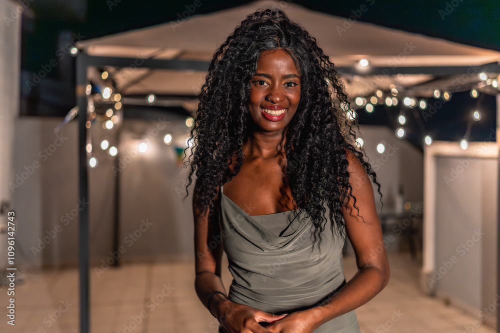 Beauty african woman standing smiling in a night roof party Beauty african woman standing smiling in a night roof party