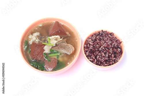 Pork blood jelly soup with entrials and riceberry rice (Oryza sativa) in light orange ceramic bowl on white background. photo