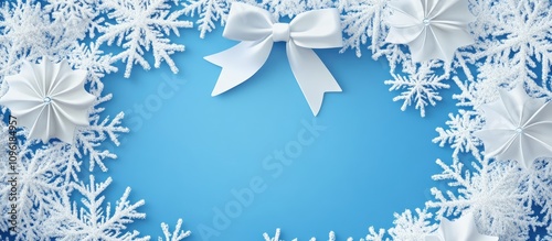 Elegant snowflake frame with white bows on a serene blue background ideal for winter themed designs and holiday promotions photo