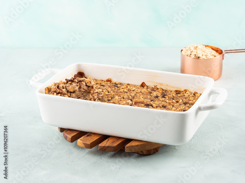 Vegan oatmeal banana cake in white baking pan on turquoise