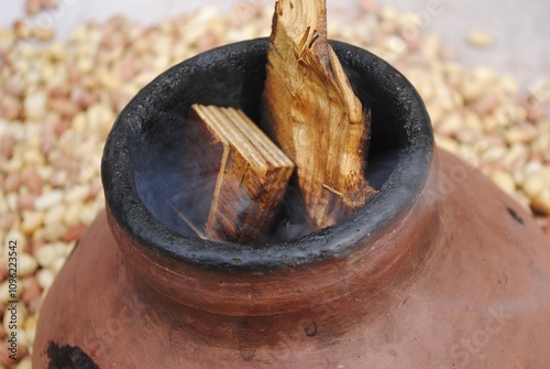 In India Peanuts are make hot by putting wooden piece in earthen pot  photo