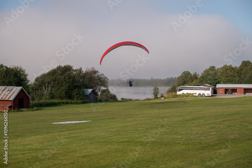 A paraglider landing in fog