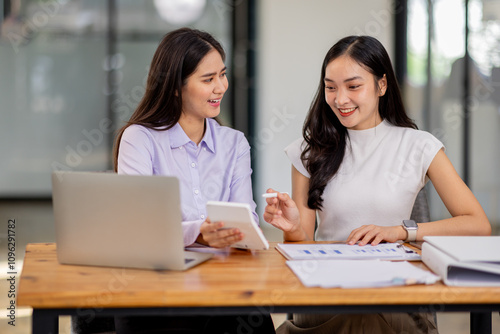 Financial Business two women analyze the graph of the company's performance to create profits and growth, Market research reports and income statistics, Financial and Accounting concept. 