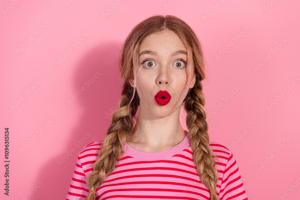 Beautiful young woman with braids and red pomade posing in a striped t-shirt against a vibrant pink background Beautiful young woman with braids and red pomade posing in a striped t-shirt against a vibrant pink background