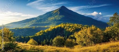 Majestic mountain towering above a lush green forest during a vibrant sunset landscape scene.