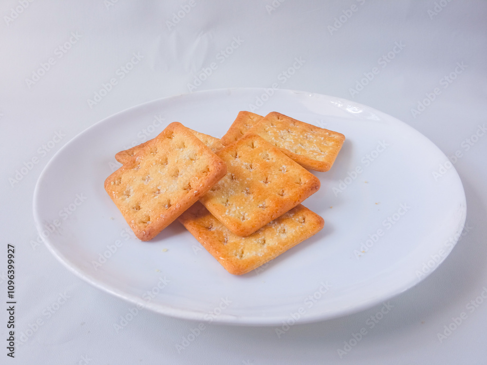 Sugar coated biscuits, also known as malkist, sweet and crispy. Served on white plate Sugar coated biscuits, also known as malkist, sweet and crispy. Served on white plate