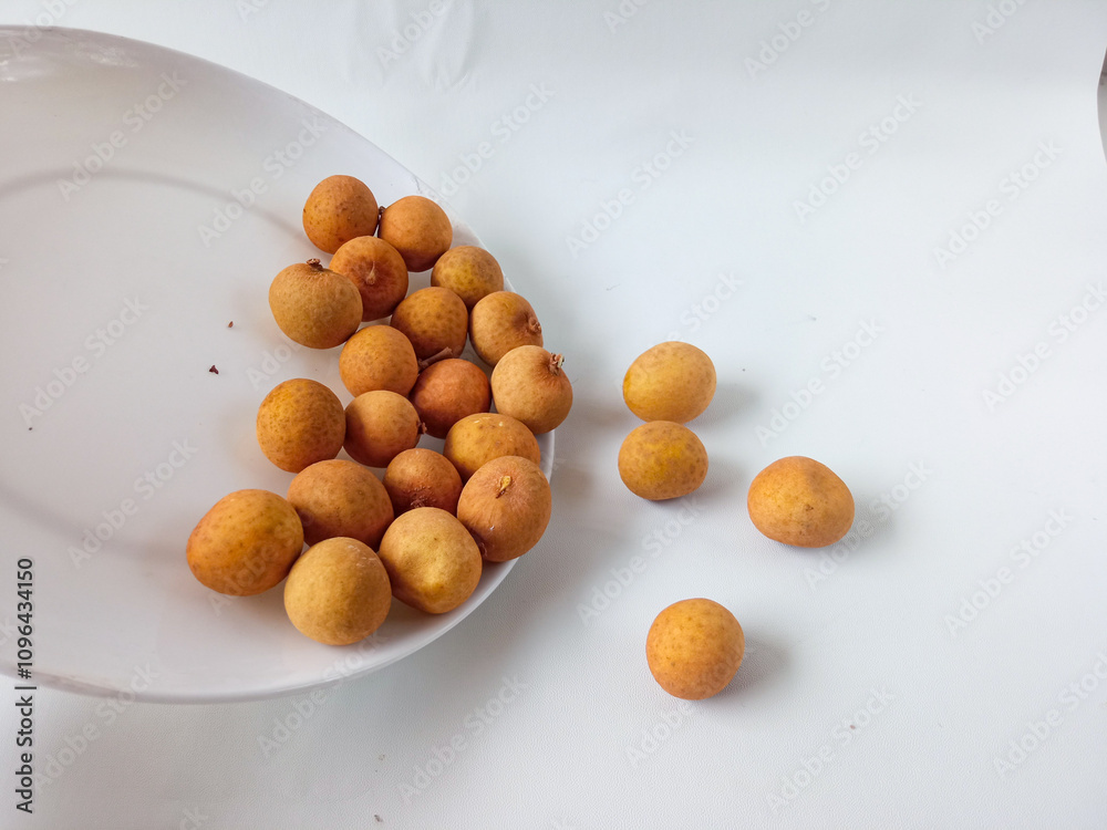 longan fruit on a white round plate isolate on white background longan fruit on a white round plate isolate on white background