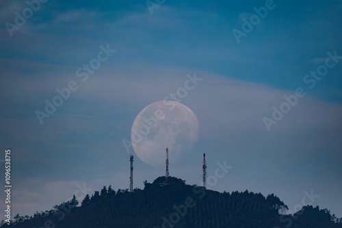 waning moon hiding in the morning between clouds