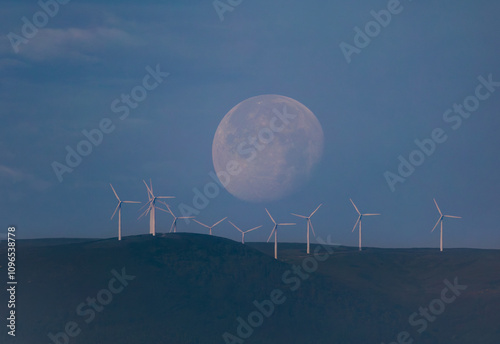 waning moon hiding in the morning between clouds