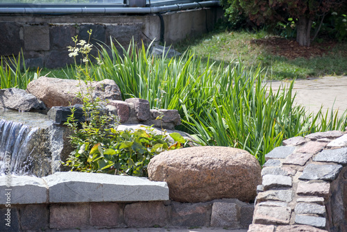 A stone garden with flowers and a small waterfall between the stones