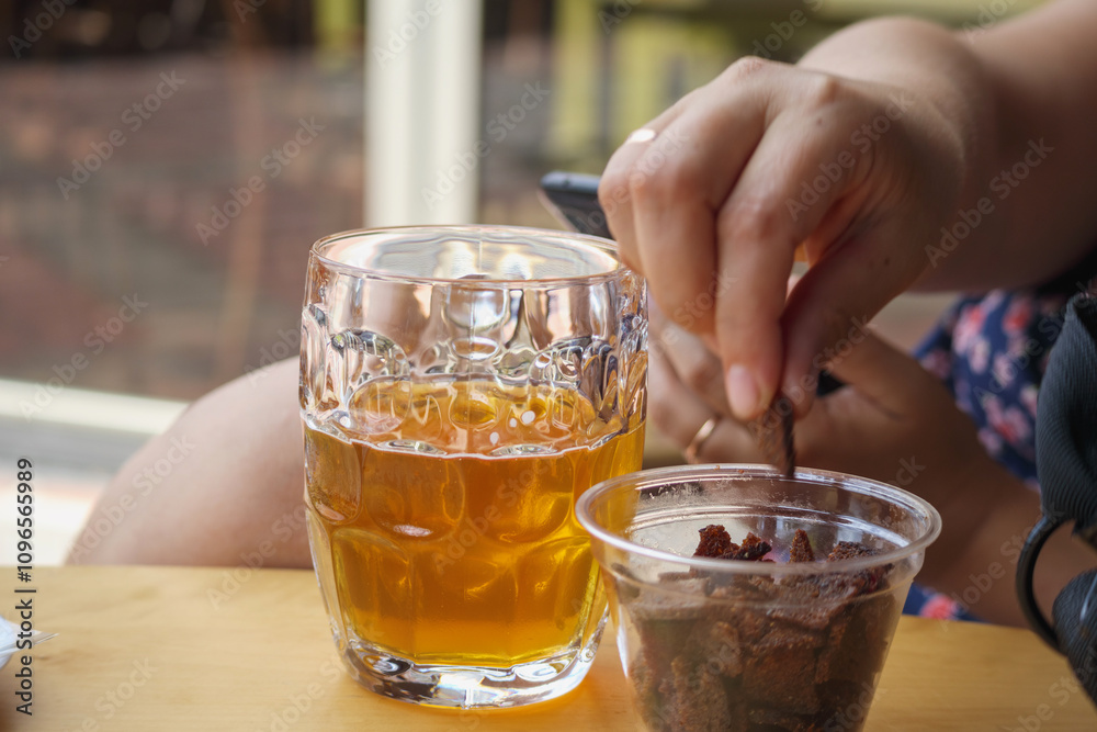 a glass of beer on the table and a snack of toast with garlic