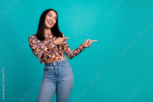 Portrait of nice young girl indicate fingers empty space wear top isolated on turquoise color background