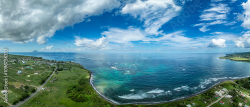 Aerial view of beautiful Dieppe beach bay with a black sand beach, palm trees, and a reef that protects swimmers and snorkelers om St Kitts where the Caribbean sea and the Atlantic Ocean meet  photo