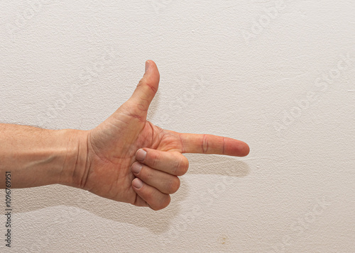 A close-up view of a hand gesturing the number two against a white background photo