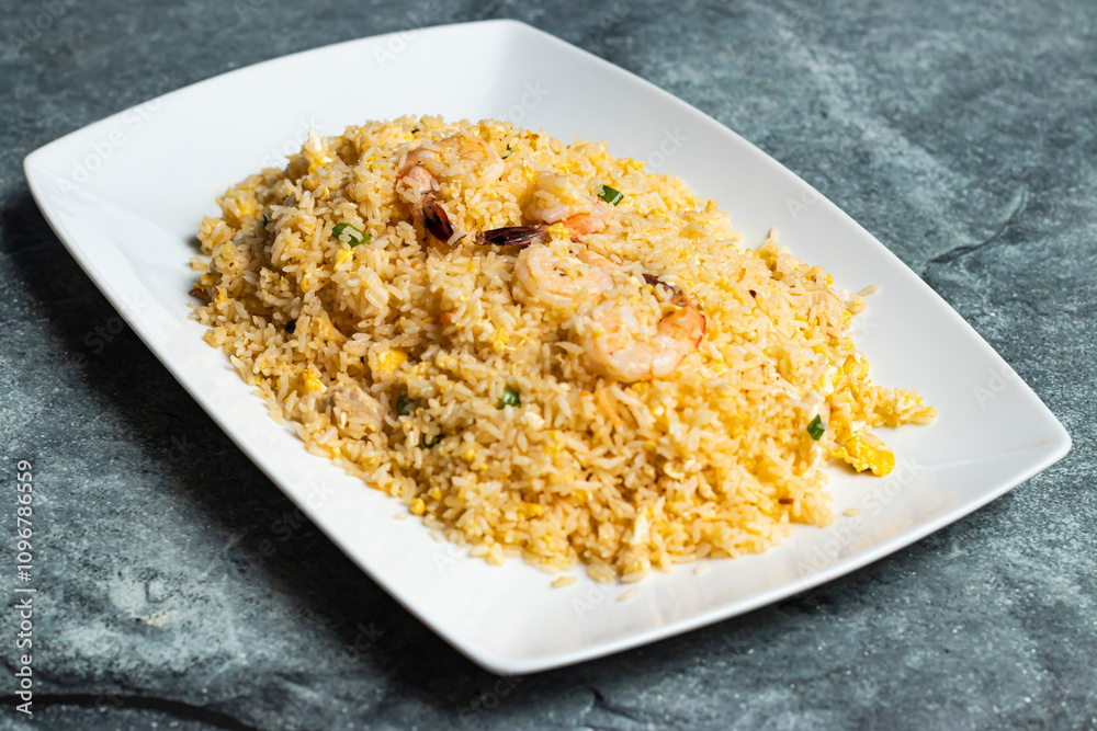 Mixed fried Rice with shrimp, prawn, egg and chicken served in tray dish isolated on grey background side view of thai food Mixed fried Rice with shrimp, prawn, egg and chicken served in tray dish isolated on grey background side view of thai food