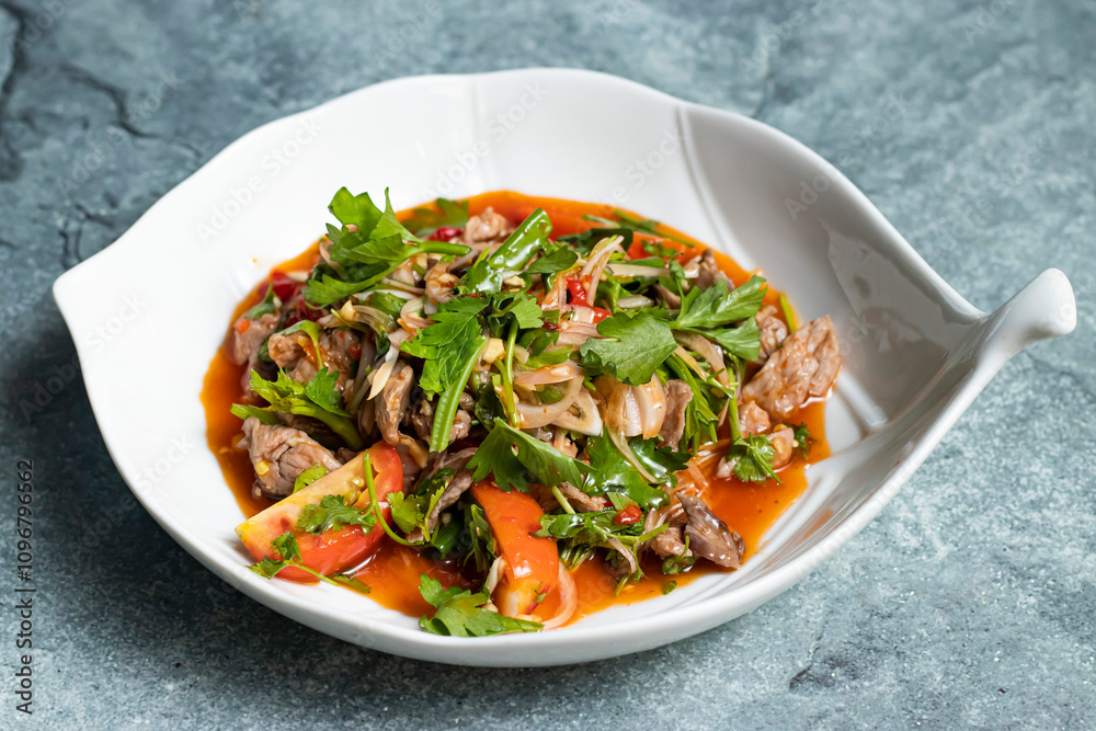 Beef Salad including tomato, onion, coriander and gravy served in bowl isolated on grey background side view of thai food