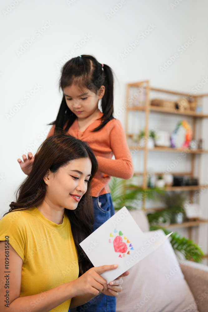 cheerful asian daughter give card hugging happy mother Good time at home. cheerful asian daughter give card hugging happy mother Good time at home.