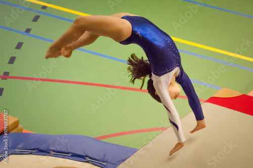 Young gymnast girl performing jump back handspring