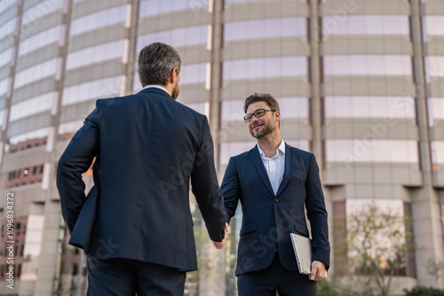 Celebrate business partnership. Two businessmen partner celebrating business deal. Successful partnership in business deal. Businessmen dealing outdoor. Partnership success. Cooperation.