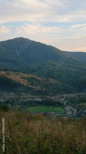 Scenic Village with Train Passing Through Lush Green Mountains photo