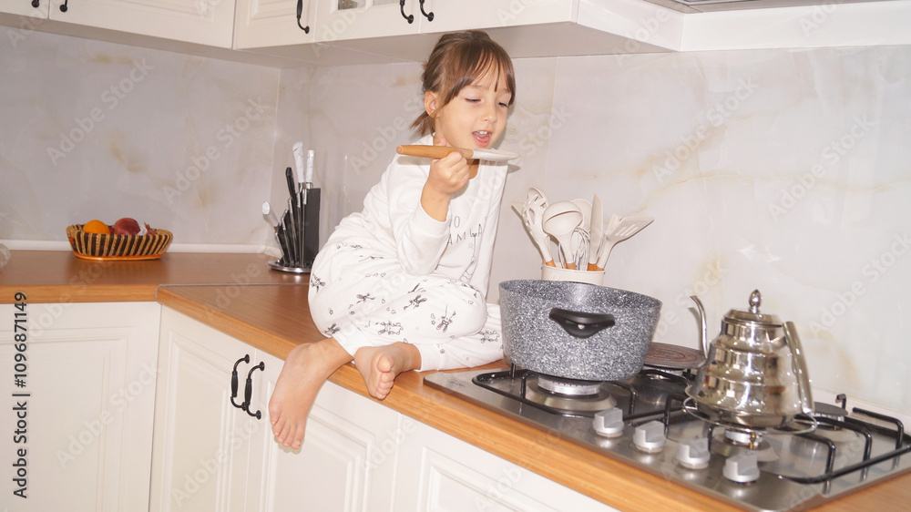 Little chef is sitting on the kitchen table and cooking dinner . High quality photo Little chef is sitting on the kitchen table and cooking dinner . High quality photo