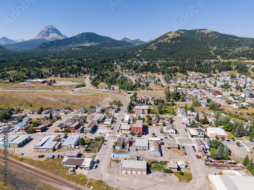 Aerial old coal mining town overlooking distant landmark mountains along the Crowsnest Pass in Southern Alberta. photo