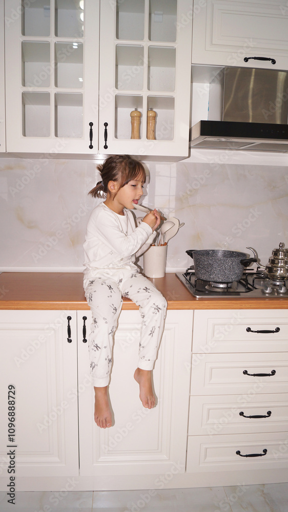 Little chef is sitting on the kitchen table and cooking dinner . High quality photo Little chef is sitting on the kitchen table and cooking dinner . High quality photo