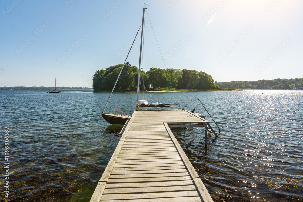 Sailboat at a pier in a beautiful bay between small islands (Store Okseø or Ochseninsel) in the Baltic Sea Sailboat at a pier in a beautiful bay between small islands (Store Okseø or Ochseninsel) in the Baltic Sea